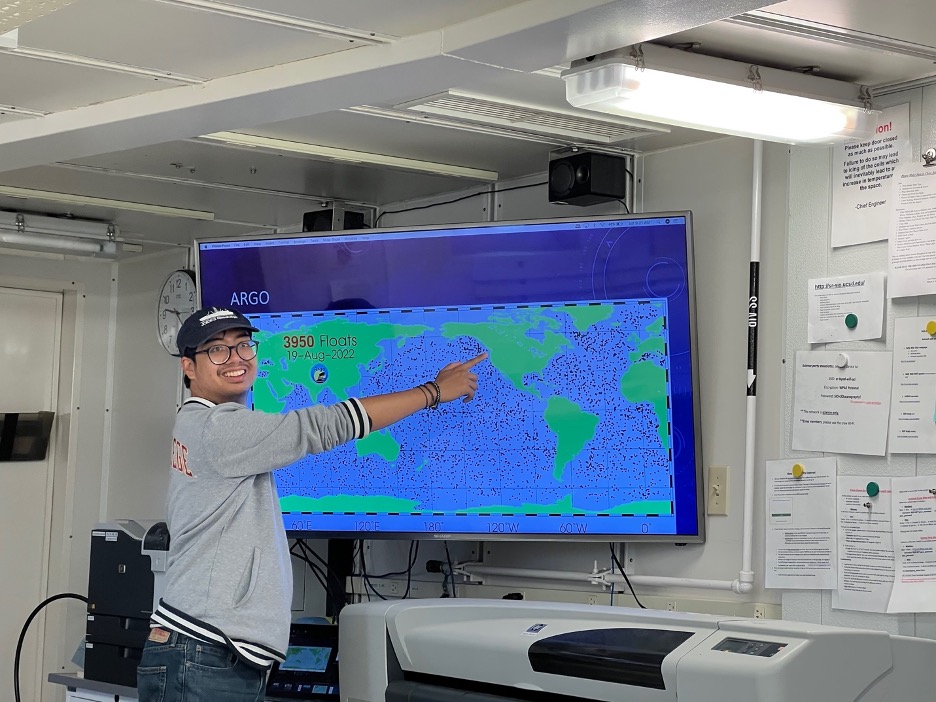 A man points to a map of the world with tiny dots covering the ocean, indicating the positions of the ARGO drones.